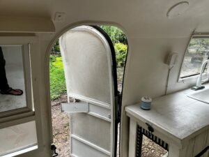 Looking out through the open door from inside the trailer, into the garden
