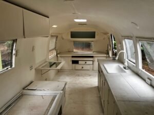 Inside, looking to the far end: white cabinets, the sink and counter, and a window
